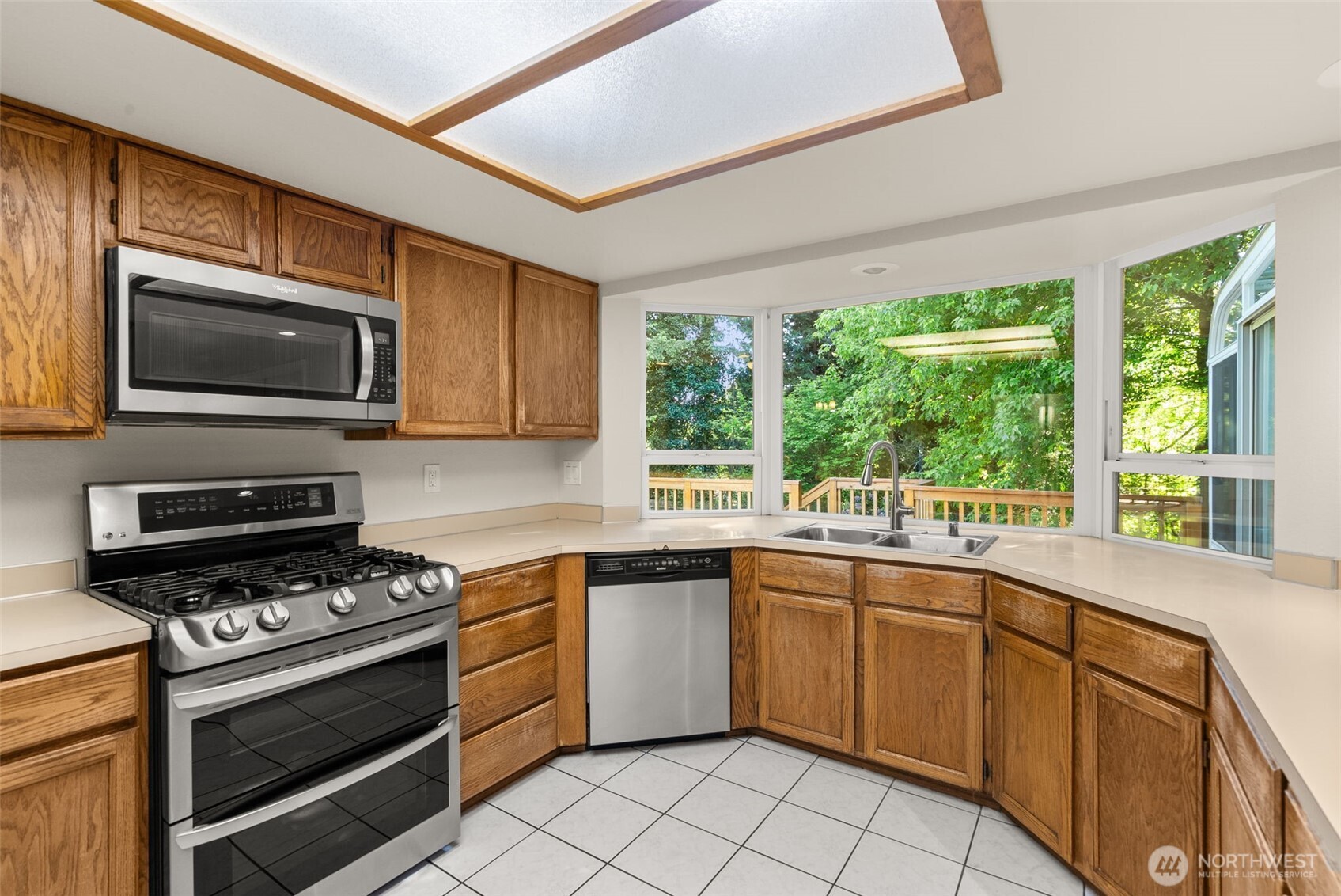 13603 Southeast 239th Street Kent, WA 98042 - Photo 4 of 23 a kitchen with a stove a sink and a microwave