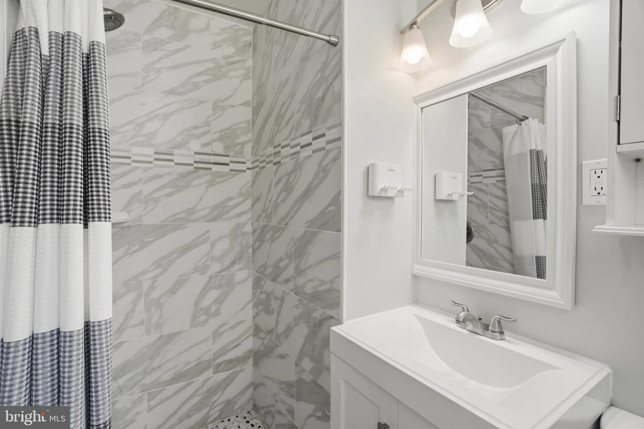 810 Venice Drive Silver Spring, MD 20904 - Photo 14 of 33 a bathroom with a sink a shower and a mirror