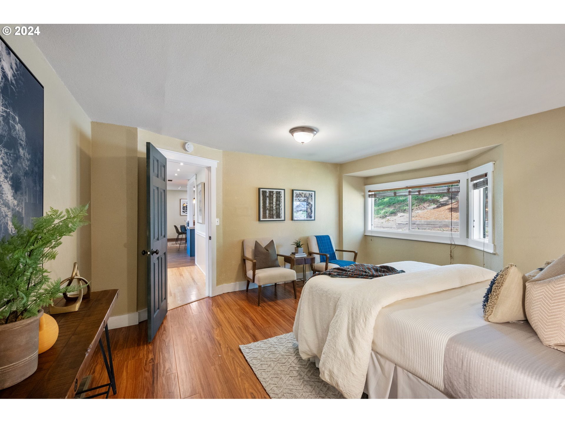 8511 Southeast Barbara Welch Road Portland, OR 97236 - Photo 11 of 30 a bedroom with a bed and wooden floor