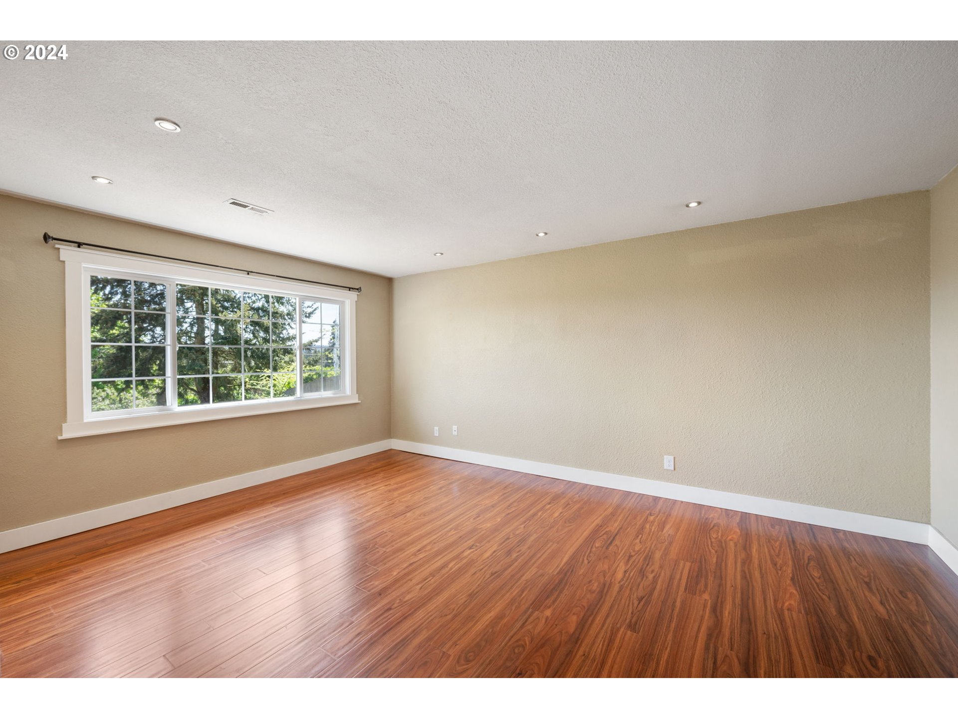 8511 Southeast Barbara Welch Road Portland, OR 97236 - Photo 15 of 30 a view of an empty room with wooden floor and a window