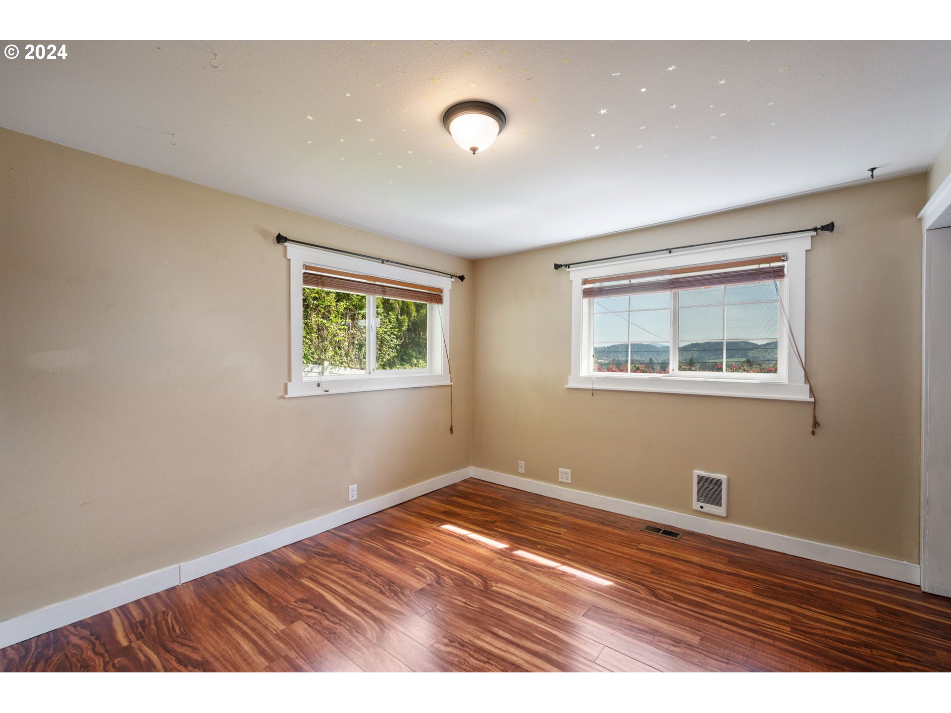 8511 Southeast Barbara Welch Road Portland, OR 97236 - Photo 18 of 30 a view of an empty room with wooden floor and a window