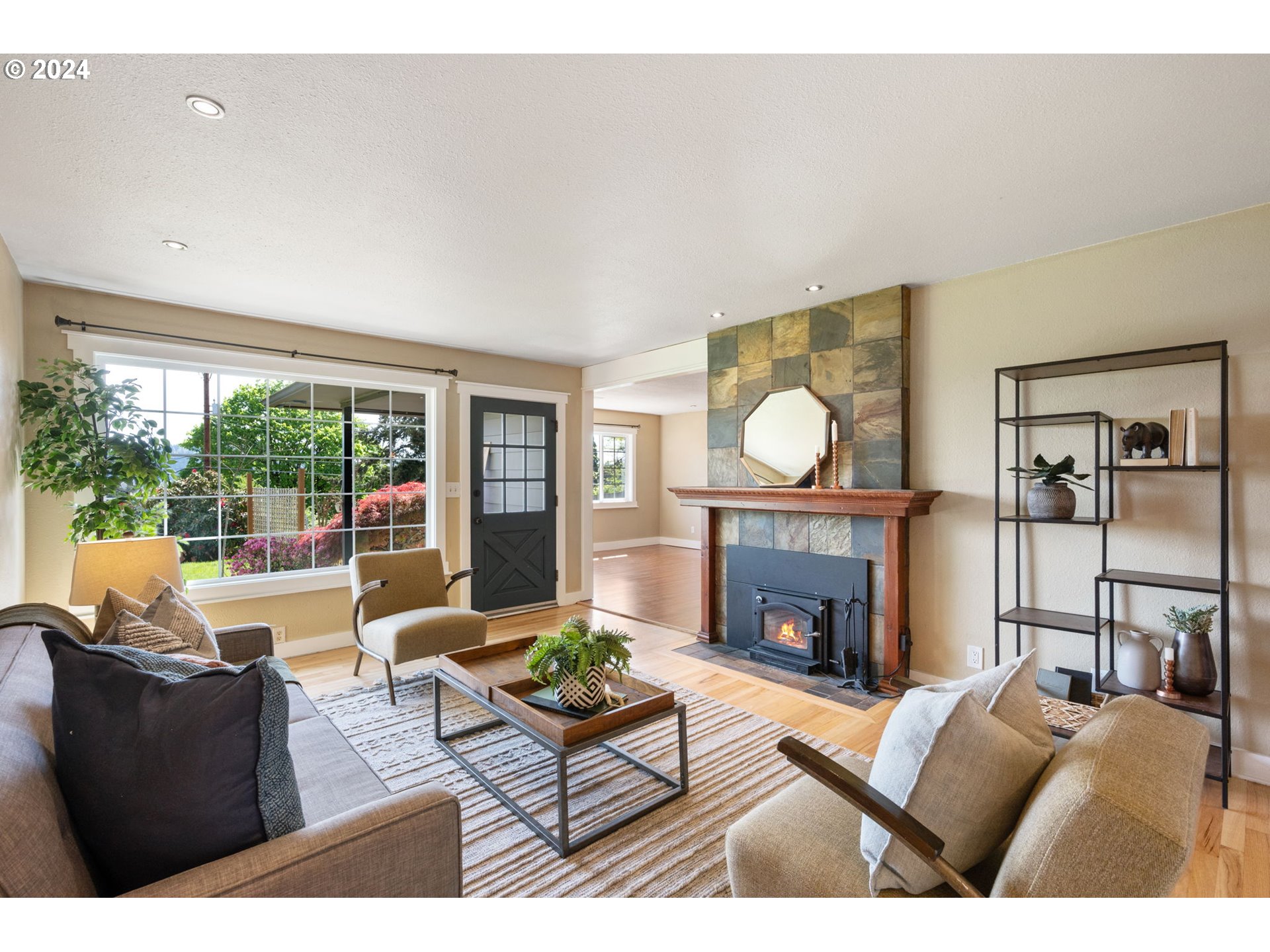 8511 Southeast Barbara Welch Road Portland, OR 97236 - Photo 4 of 30 a living room with furniture a fireplace and a floor to ceiling window