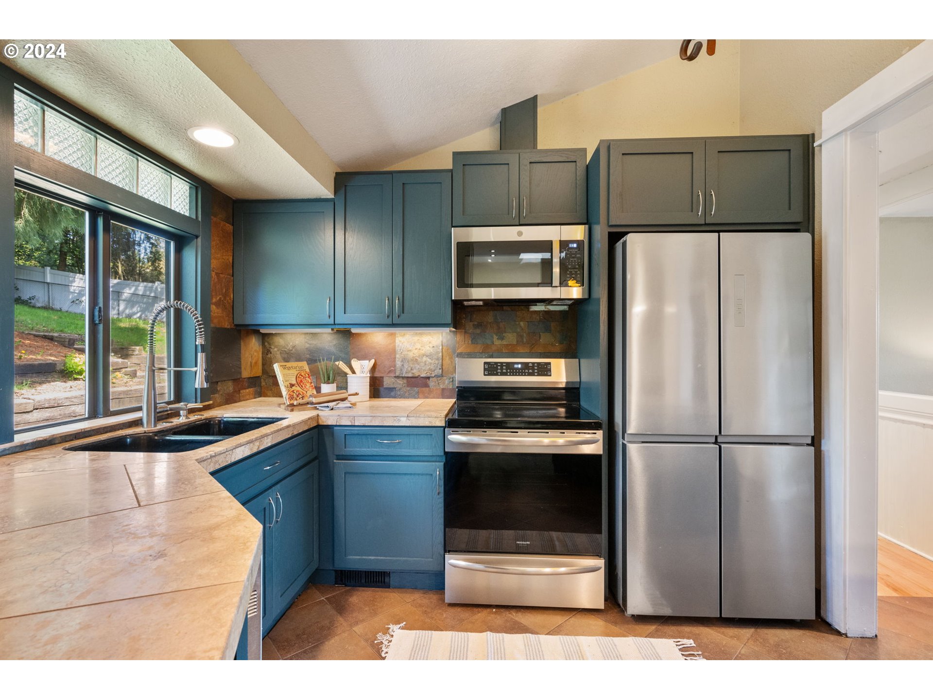 8511 Southeast Barbara Welch Road Portland, OR 97236 - Photo 7 of 30 a kitchen with stainless steel appliances granite countertop a refrigerator a stove a sink and a microwave