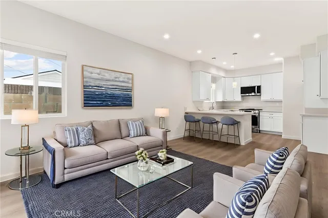 a living room with furniture kitchen view and a window
