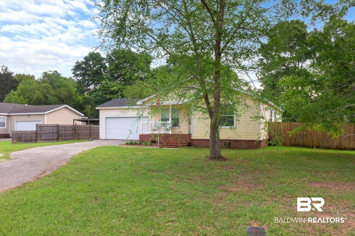 6971 March Road Theodore, AL 36582 - Photo 3 of 26 View of front facade with aphalt driveway, fence, an attached garage, crawl space, and a front yard