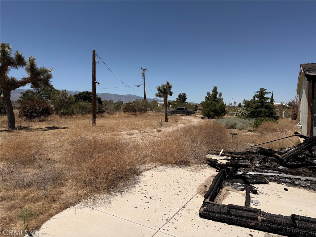 12225 Lager Road Phelan, CA 92371 - Photo 14 of 18 Close-up of collapsed roof and fire damage on home corner