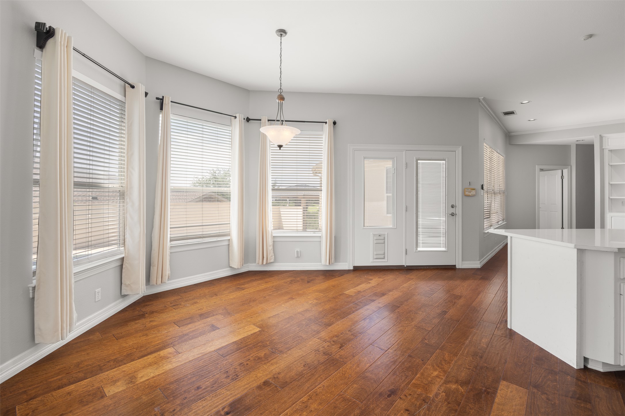 9300 Simmons Road Austin, TX 78759 - Photo 6 of 17 Rich hardwood flooring and ample natural light define this welcoming dining area, perfect for gatherings.
