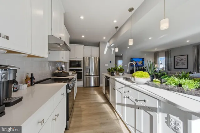 a kitchen with stainless steel appliances kitchen island granite countertop a stove a sink and a refrigerator
