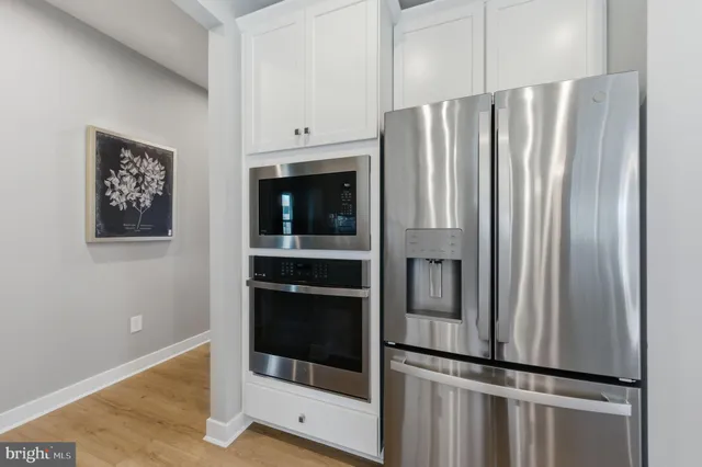 a kitchen with stainless steel appliances wooden floor and electronic appliances