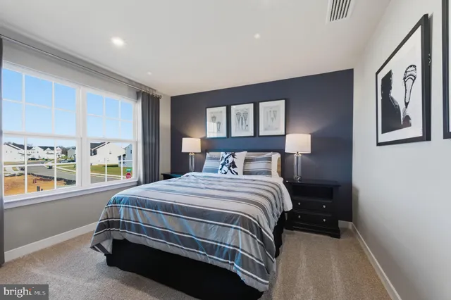 a bedroom with a bed and dresser next to a window