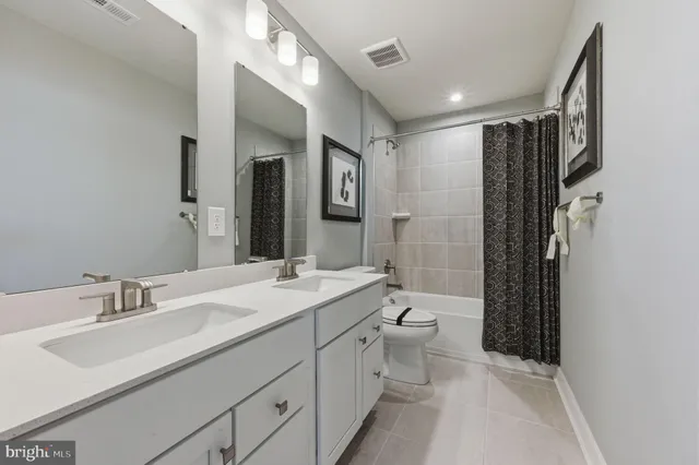 a bathroom with a double vanity sink toilet and shower