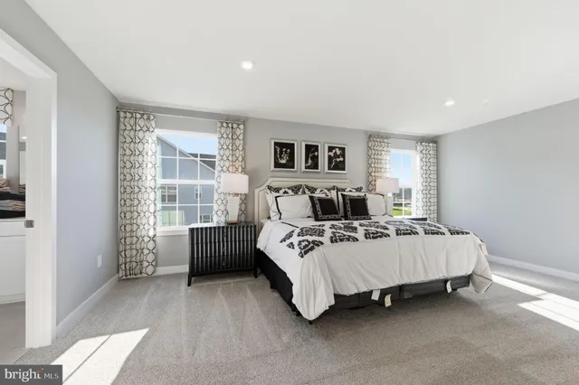 a spacious bedroom with a bed lamp and a window