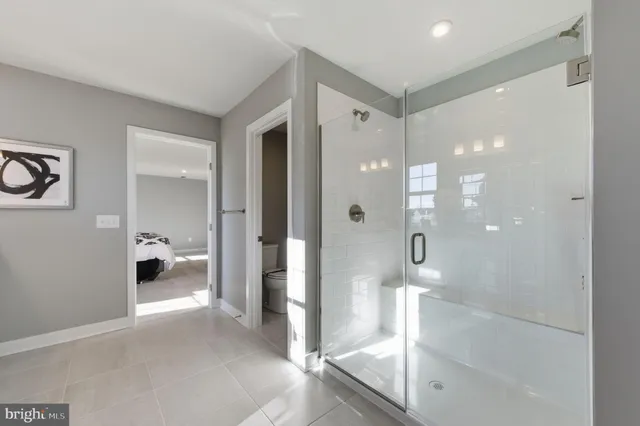 a bathroom with a glass shower door and a glass door