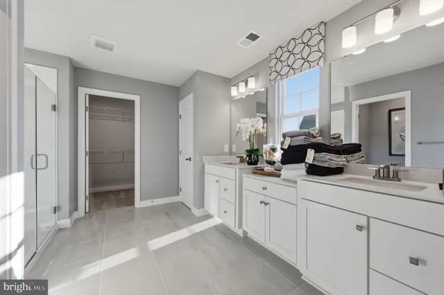 a spacious bathroom with double sink and a mirror