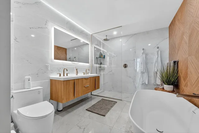 a bathroom with a granite countertop sink toilet and shower