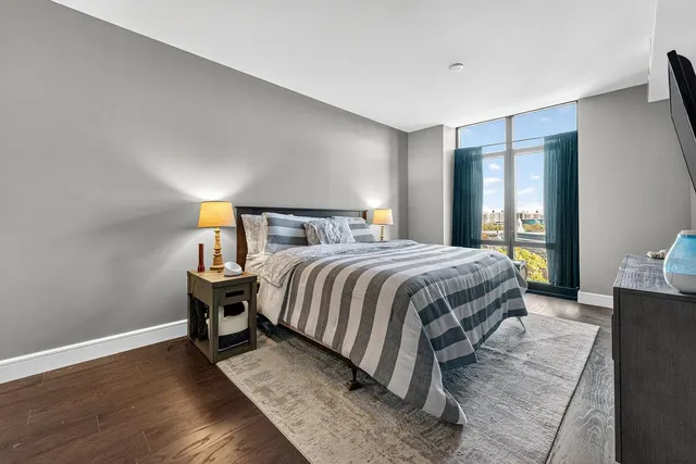 a bedroom with a bed and wooden floor