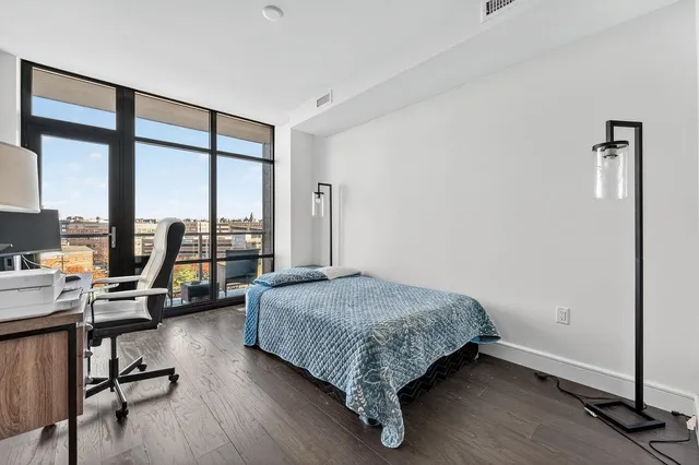 a spacious bedroom with a bed and large windows