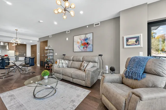 a living room with furniture a chandelier and a flat screen tv