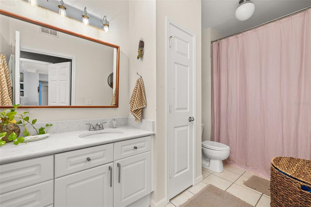 215 Longview Avenue, Unit 104 Celebration, FL 34747 - Photo 15 of 22 a bathroom with a toilet sink and mirror
