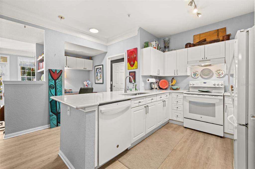 215 Longview Avenue, Unit 104 Celebration, FL 34747 - Photo 5 of 22 a kitchen with cabinets appliances wooden floor and a window