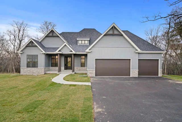 a front view of a house with yard and garage