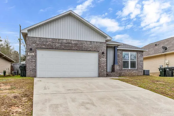 a front view of a house with a garden and yard