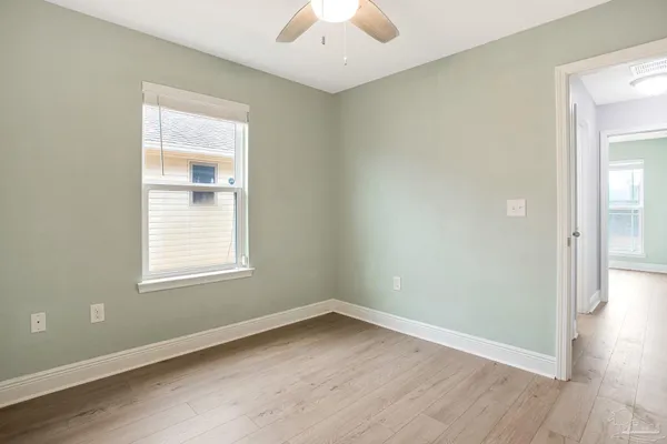 an empty room with a window and wooden floor
