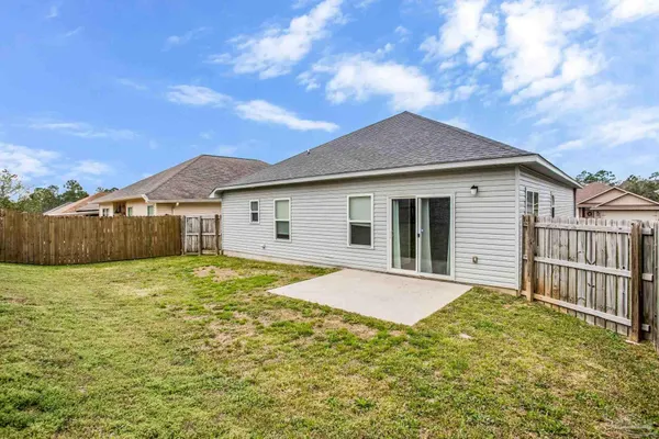 a view of a house with a yard and wooden fence