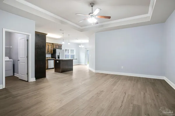 a view of a kitchen with a fridge wooden floor and a kitchen