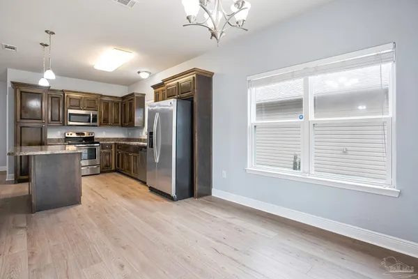 a kitchen with stainless steel appliances granite countertop a refrigerator a sink dishwasher a stove and a refrigerator