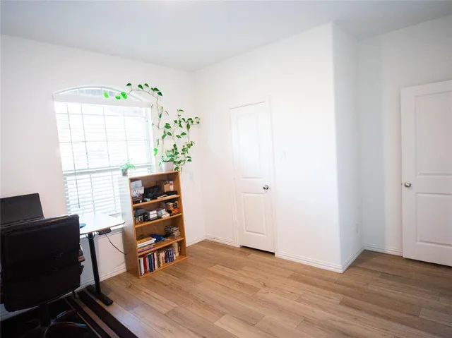 a view of a workspace with furniture and a window