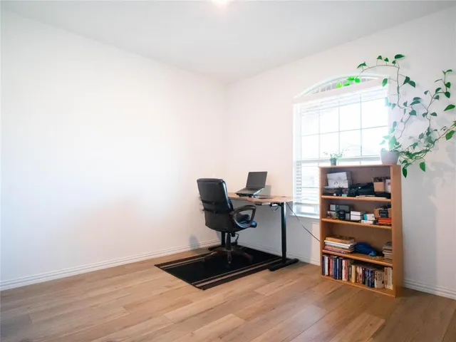 a view of a workspace with furniture and a window