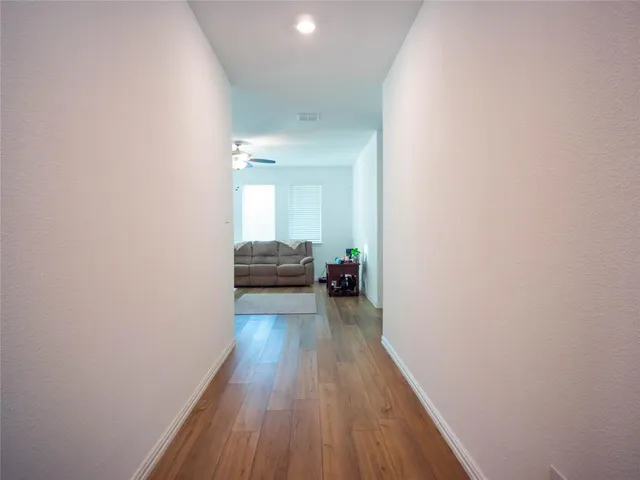 a view of a hallway with wooden floor and staircase