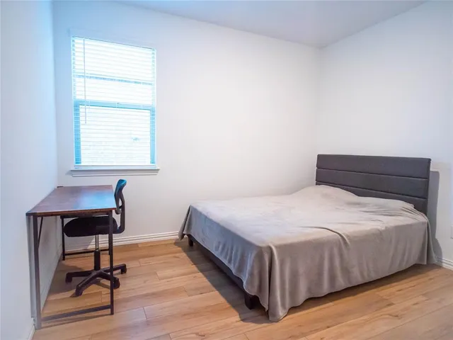 a bedroom with a bed a table and a window