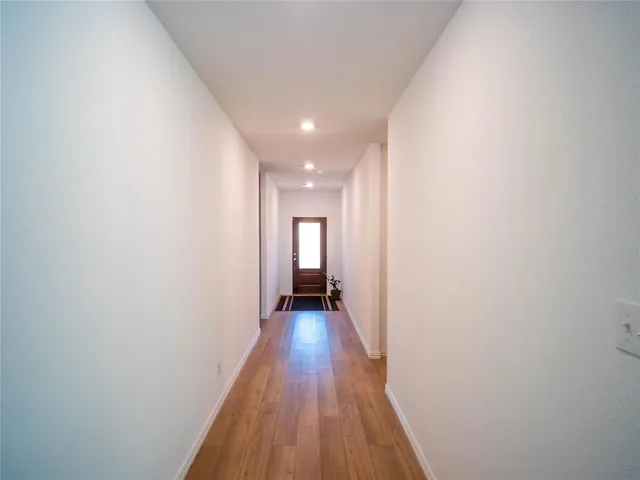 a view of a hallway with wooden floor