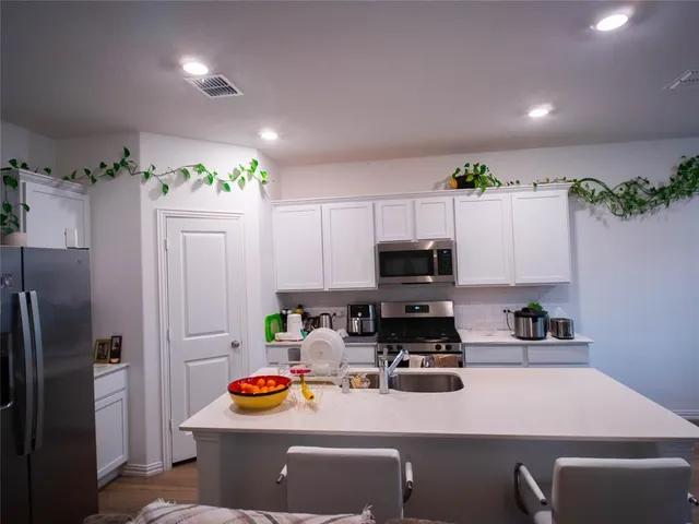 a kitchen with a refrigerator and a stove top oven