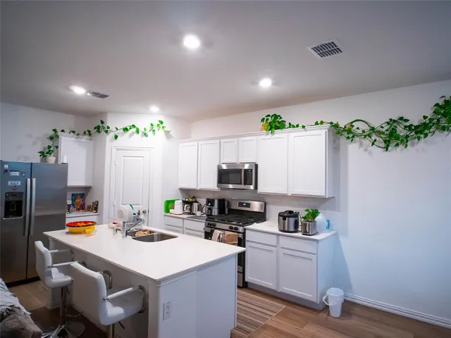 a kitchen with kitchen island a white counter top space cabinets and appliances