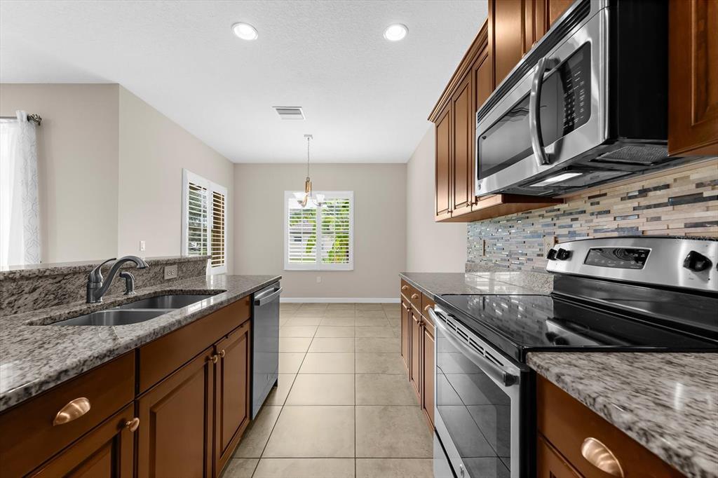 4326 Forest Creek Trail Parrish, FL 34219 - Photo 15 of 73 a kitchen with stainless steel appliances granite countertop a sink stove and cabinets