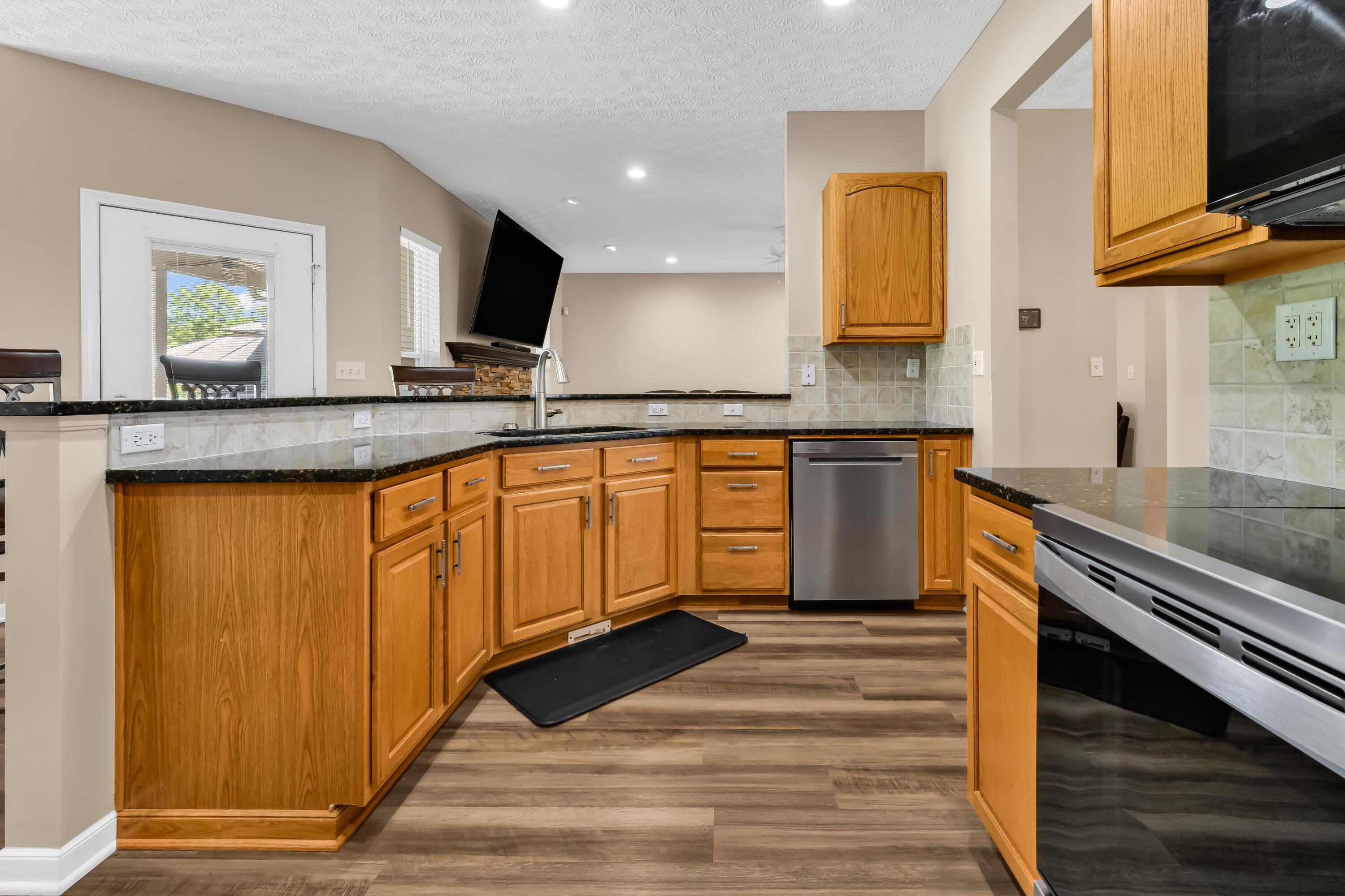 14396 Blamer Road Johnstown, OH 43031 - Photo 15 of 48 • Luxury vinyl plank flooring
• Tan painted walls
• Granite countertops
• New Whirlpool® refrigerator
~ 2025
• New Whirlpool® microwave
~ 2025
• New Whirlpool® electric
range ~ 2025
• New Whirlpool® dishwasher
~ 2025
• Peninsula with breakfast bar
ledge
• Double bowl, stainless steel
sink with sprayer
• New disposal ~ 2026
• Tile backsplash
• Raised panel cabinets