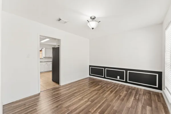 a view of a bedroom with a bed and wooden floor