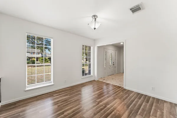 a kitchen with granite countertop white cabinets white stainless steel appliances with a sink and dishwasher next to a window