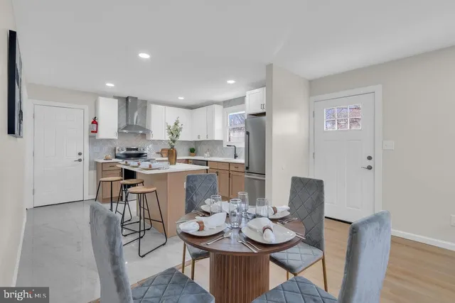 a kitchen with a dining table chairs and refrigerator