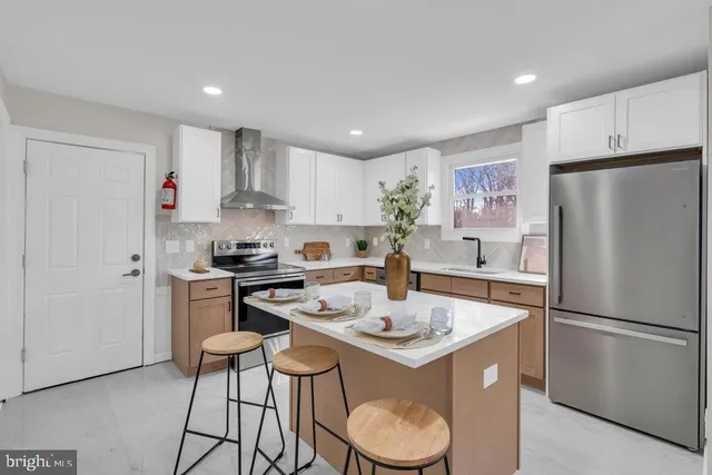 a kitchen with a sink a refrigerator and white cabinets