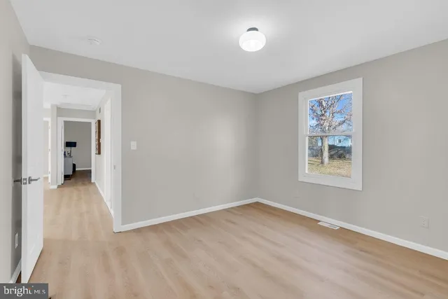 a view of a room with wooden floor and a window
