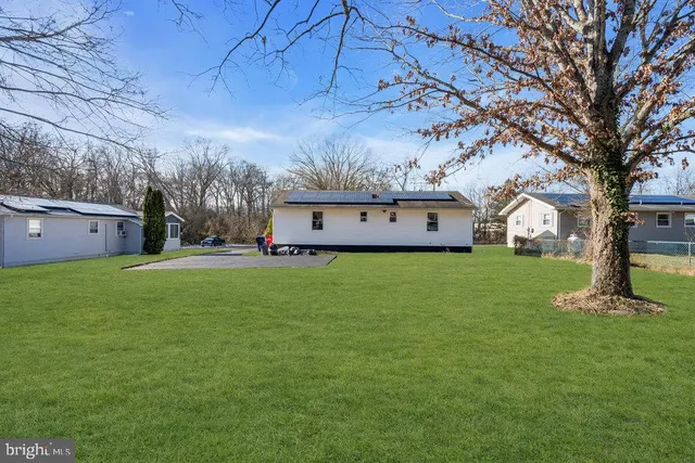 a front view of house with yard and trees in the background