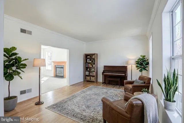 an empty room with wooden floor chandelier and windows