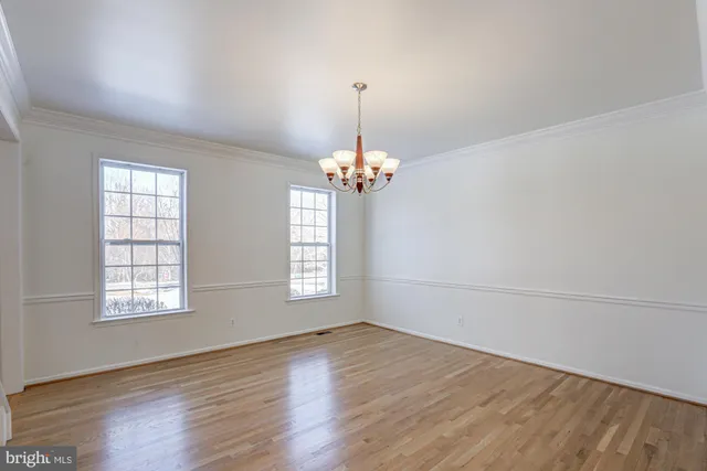 a dining room with furniture a chandelier and wooden floor