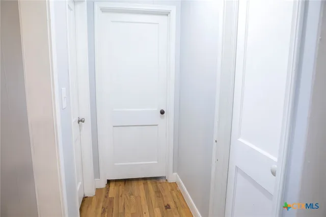 a view of a hallway with wooden floor