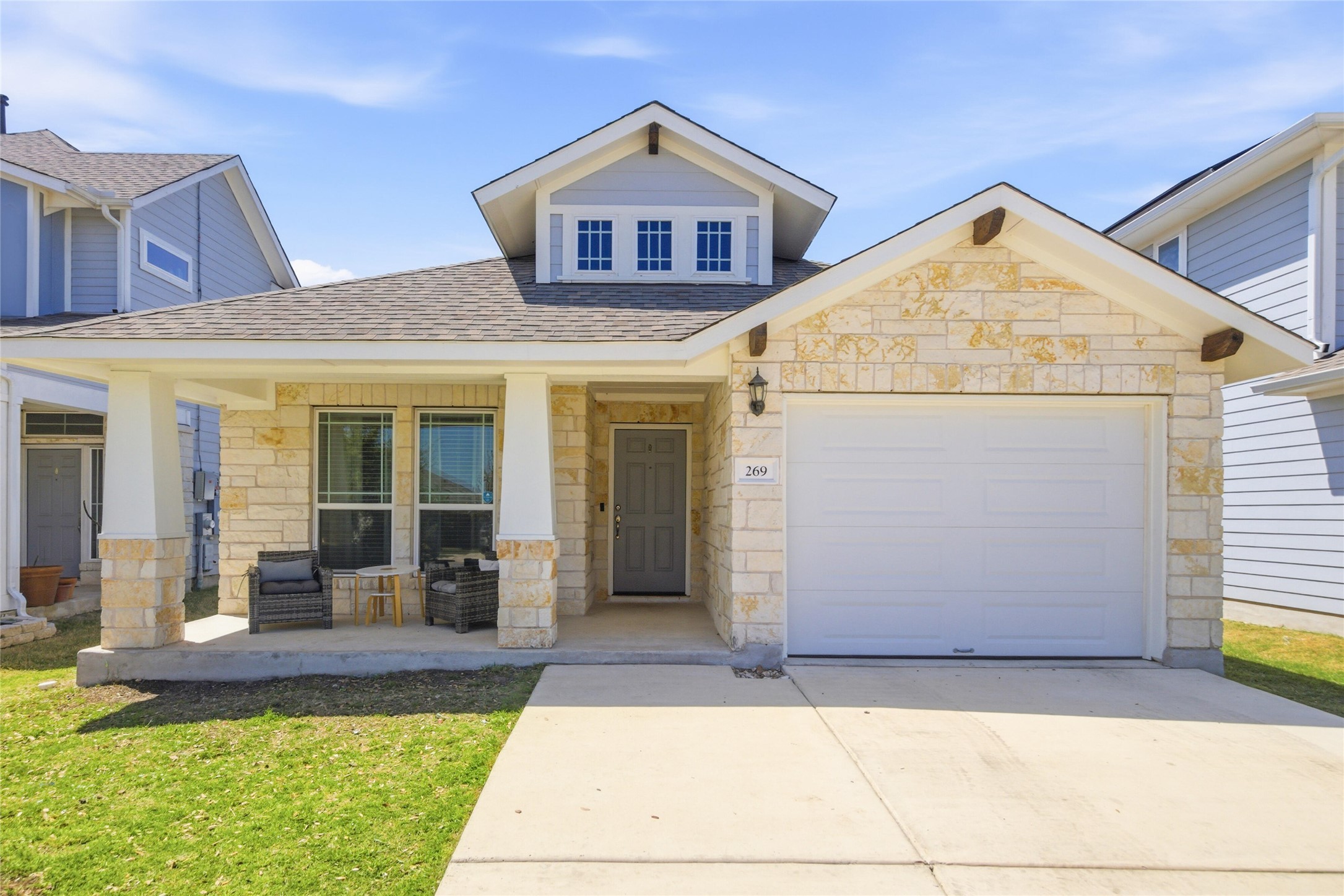 269 Gaida Loop Georgetown, TX 78628 - Photo 1 of 20 View of front facade with stone siding, a garage, a porch, and concrete driveway