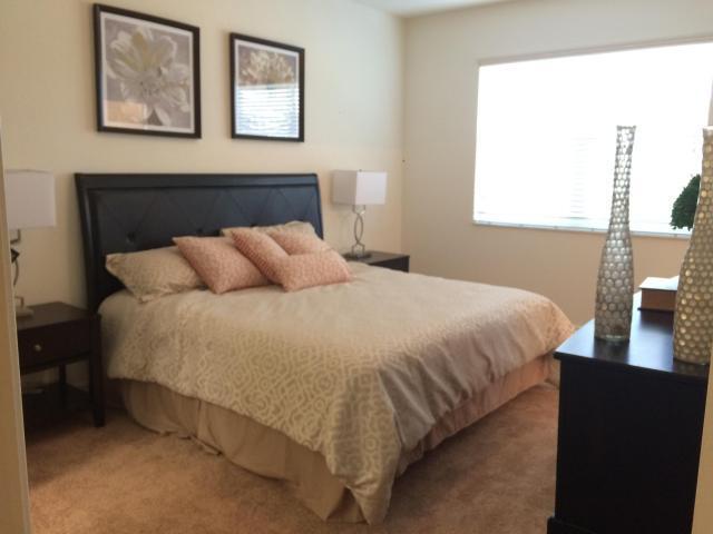 9503 Southwest Merlin Court Stuart, FL 34997 - Photo 4 of 6 a bedroom with a bed and a night stand